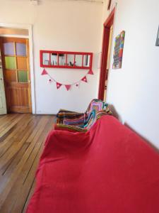 Habitación con una manta roja en el suelo en Hostal Mirenart, en Valparaíso