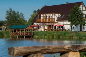 a large building next to a body of water at U Górala in Cieszków