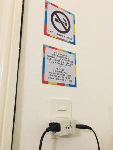 a sign on a wall with a no smoking sign at LOPEZ Hostel & Suites in Buenos Aires