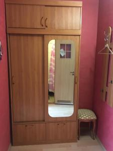 a medicine cabinet with a mirror and a stool at Severniy Hotel in Ukhta