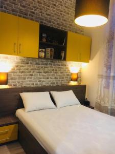 a bedroom with a large bed with yellow cabinets at ZEN Apartments Oradea in Oradea