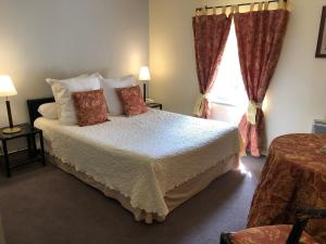 a bedroom with a bed with pillows and a window at Le Moulin De La Beune in Les Eyzies-de-Tayac