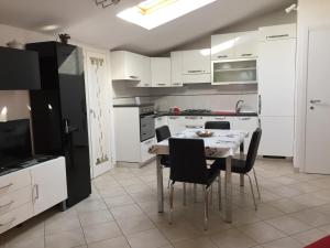 una cucina con tavolo ed elettrodomestici in bianco e nero di Appartamenti la Castagna ad Abbadia San Salvatore