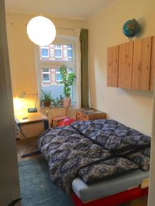 1 dormitorio con cama, escritorio y ventana en Feldstraße 10, en Lüneburg