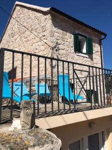 - un balcon avec des chaises bleues et un bâtiment dans l'établissement Villa San Marco, à Hvar