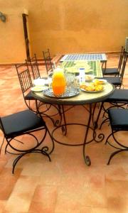 a table with a plate of food and orange juice at Joudia in Temara
