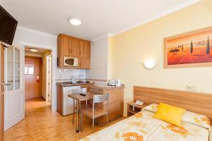 a room with a bed and a kitchen with a table at Apartamentos Stella Maris - Marcari SL in Fuengirola