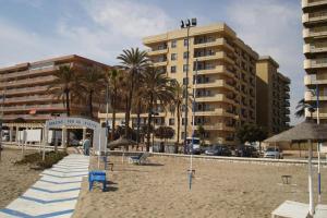 plaża z palmami i budynek w obiekcie Apartamento Ronda 4 - Los Boliches w mieście Fuengirola