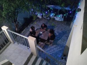 un grupo de personas sentadas en una mesa por la noche en Simabo's Backpackers' Hostel en Mindelo