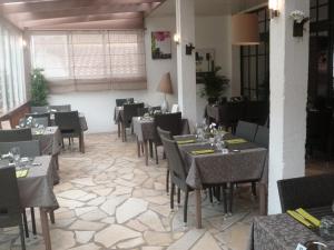 a restaurant with tables and chairs in a room at Hôtel Restaurant Les Falaises in Bouziès