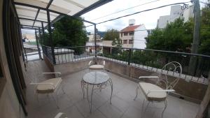 patio con mesa y sillas en el balcón en La Quinta Residencia en Salta