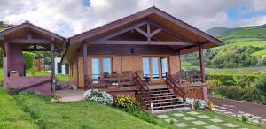 una piccola casa di legno con un portico e un portico di Quinta da Pavoa - Cottage House a Vila Franca do Campo