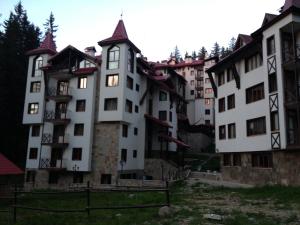 un gran edificio blanco con una torre de reloj en Ski Apartment in Castle Complex, en Pamporovo