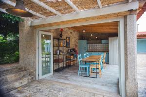 Casa Lugar da Aldeia في بارسيلوس: فناء مع طاولة وكراسي خشبية