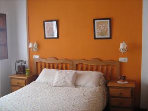 1 dormitorio con 1 cama con pared de color naranja en Astur Regal, en Cadavedo