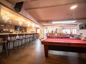 a room with a pool table and a bar at PARTY HOSTEL - The Canmore Hotel Hostel in Canmore
