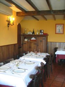 un comedor con una mesa larga con mesas y sillas blancas en Astur Regal, en Cadavedo