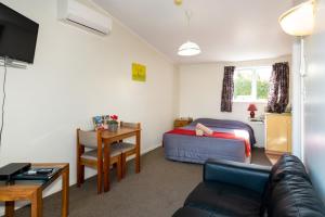 ein Wohnzimmer mit einem Bett und einem Schreibtisch in der Unterkunft Sundowner Spanish Lady Motel in Napier