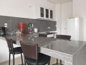 uma cozinha com uma bancada em mármore e cadeiras em Premium Loft Lorena em Lorena