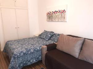 ein Wohnzimmer mit einem Sofa und einem Bett in der Unterkunft Flat Cavalinho Branco -102 in Águas de Lindóia