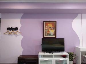 a living room with a tv on a purple wall at Happy宅 in Tainan