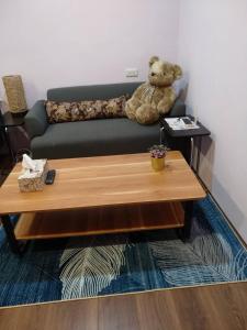 a teddy bear sitting on a couch with a coffee table at Happy宅 in Tainan