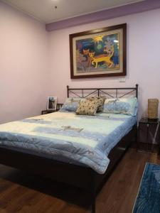 Ce lit se trouve dans une chambre ornée d'une peinture murale. dans l'établissement Happy宅, à Tainan
