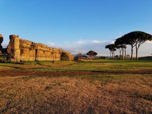 a field with trees and a rock wall at Sapphire Apartment in Rome