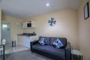 a living room with a couch and a kitchen at Abbella Lodge Motel in Christchurch