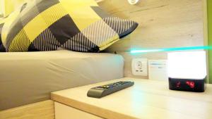 a remote control on a table next to a bed at Hotel Garni Silberburg - Schwarzwald-Plus Karte in Bad Wildbad