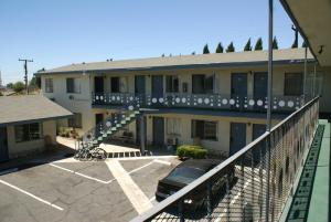 a building with a car parked in a parking lot at Sahara Motel in Anaheim