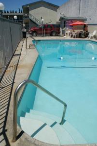 a large blue swimming pool with a metal hand rail at Sahara Motel in Anaheim