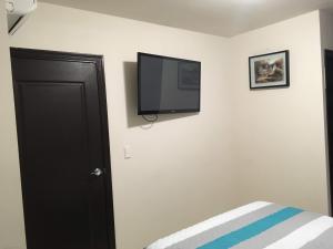 um quarto com uma televisão de ecrã plano na parede em Apartamento Climatizado, 2 Habitaciones y Piscina em Tegucigalpa