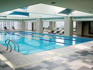 a large swimming pool with chairs in a building at Baolong Hotel Shanghai in Shanghai
