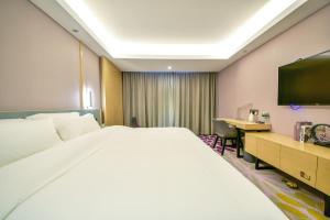 Pokój hotelowy z dużym łóżkiem i biurkiem w obiekcie Lavande Hotel Dali Erhai Park Branch w mieście Dali