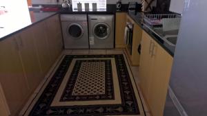 a kitchen with a washer and dryer on the floor at Milkwood House in Wilderness