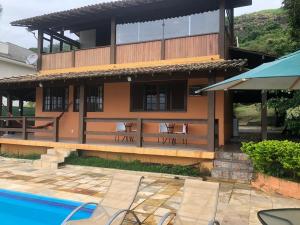 a house with a swimming pool in front of it at Itaipu Beach House in Niterói