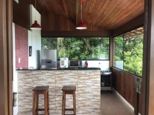 a kitchen with a counter with two stools in it at Itaipu Beach House in Niterói