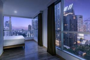 a bedroom with a bed and a view of a city at Adelphi Grande Sukhumvit in Bangkok