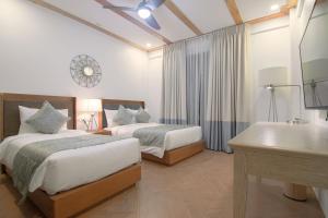 a hotel room with two beds and a sink at Thunderbird Resorts - Rizal in Binangonan