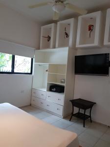 Schlafzimmer mit einem Bett und einem Flachbild-TV in der Unterkunft Na Balam Hotel in Isla Mujeres