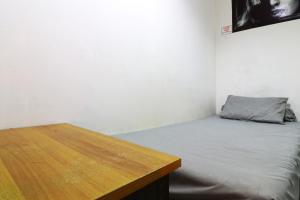 a small room with a bed and a wooden table at Wiens Residence BSD in Tangerang +16 photos