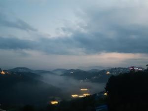 vistas a un valle nublado con edificios y luces en Duy Hotel, en Da Lat