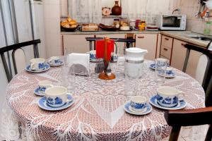 a table with cups and saucers on it in a kitchen at Pousada Casa da Cintia in Diamantina