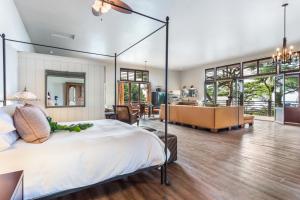 a bedroom with a large bed and a living room at Holualoa Inn in Kailua-Kona
