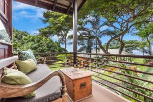 Habitación con sofá y mesa en el balcón. en Holualoa Inn en Kailua-Kona