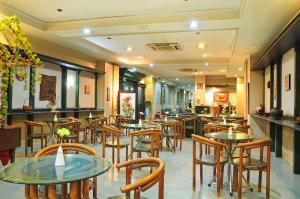 Hotel Banyuwangi Sintera في جاكرتا: مطعم فيه طاولات وكراسي في الغرفة