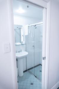 a white bathroom with a sink and a shower at Great Southern Hotel Sydney in Sydney