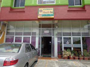 a car parked in front of a building at Hotel Musafir Inn in Padang
