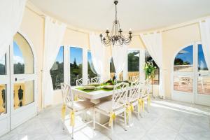 a dining room with a white table and chairs at Villa Hermosa in Jávea